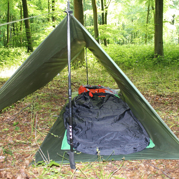 All weather shelter erected with sleeping equipment inside